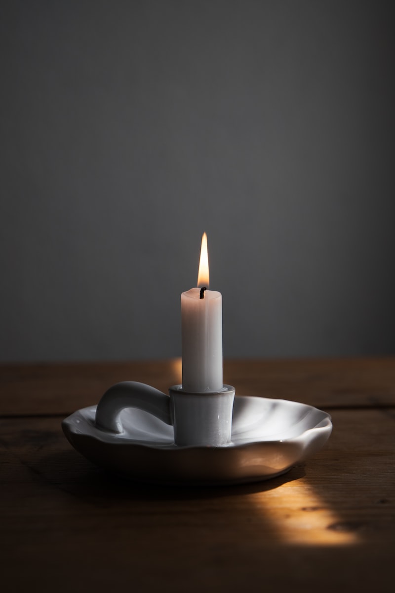 a lit candle sitting on a plate on a table